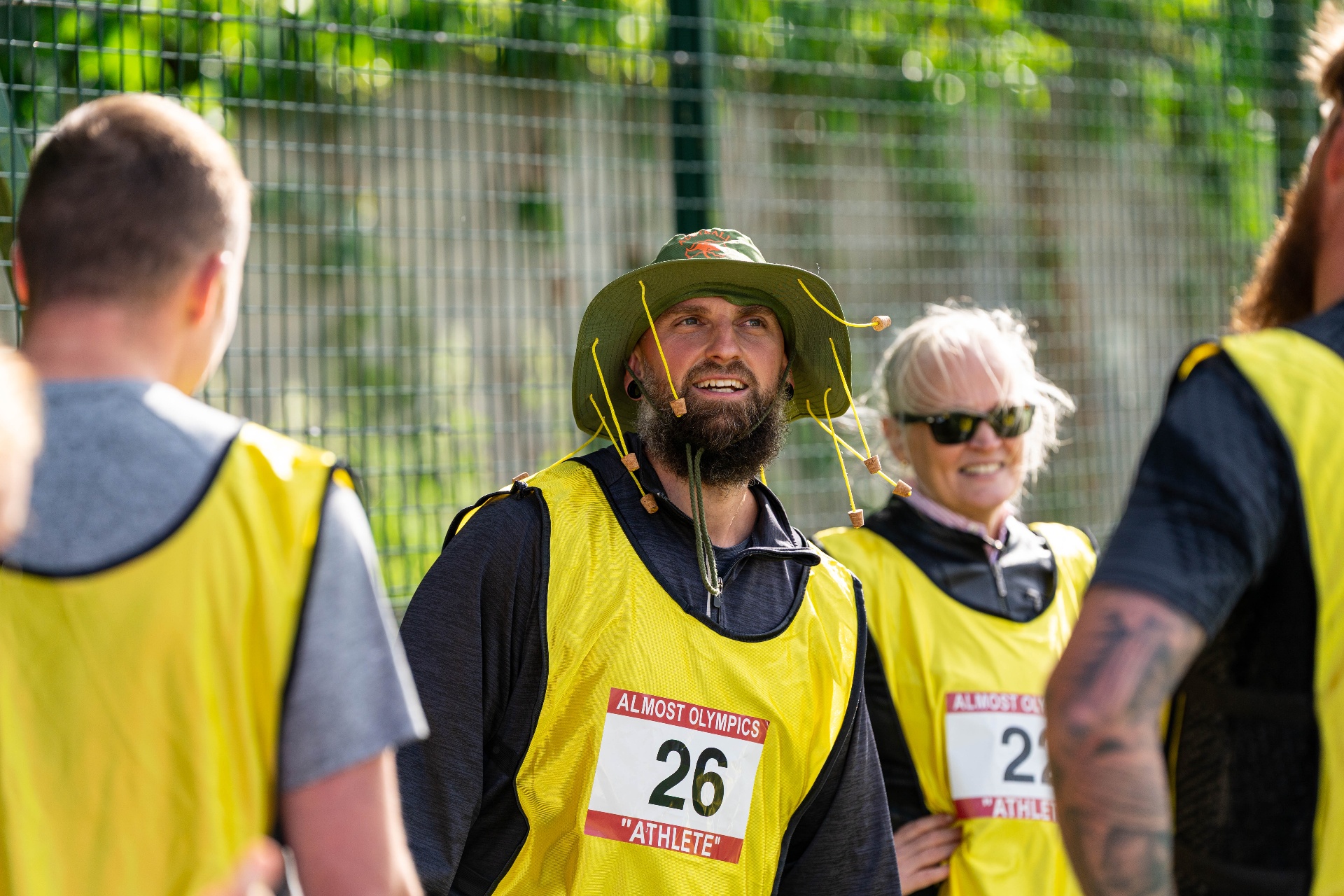 Athlete in a green hat and yellow vest at the Almost Olympics opening ceremony